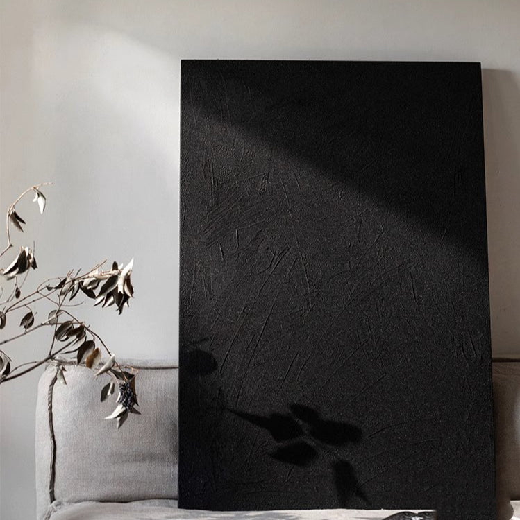 Black Textured Wall Art by RusticReach, tall black canvas with a rough textured surface leaning against a pale wall beside a sofa on Tampa Home & Garden Store