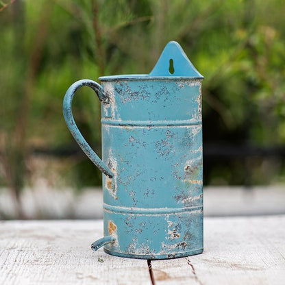 Rustic blue iron flower pot with a curved handle and distressed finish on Tampa Home & Garden Store