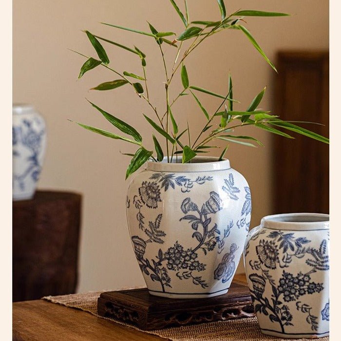 Blue and white porcelain floral vases; two vases with leafy stems on a wooden stand on Tampa Home & Garden Store