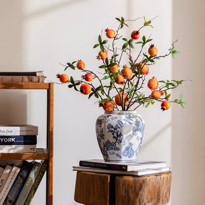 Blue and white porcelain floral vase with orange fruit branches and green leaves on a wooden pedestal RusticReach on Tampa Home & Garden Store