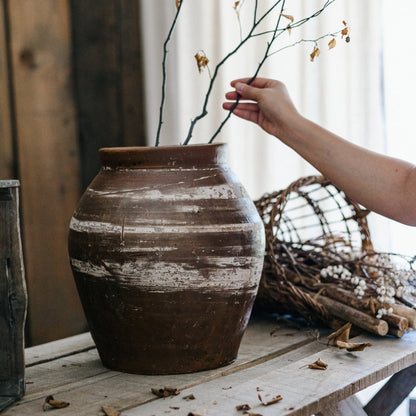 RusticReach Restoration Brown Clay Pot with distressed whitewash on a table; branches nearby on Tampa Home & Garden Store