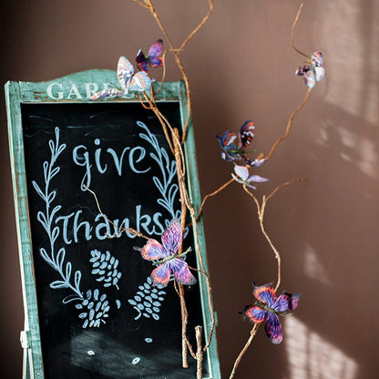 RusticReach butterfly clips set of five in purple-pink multicolor on twigs beside a chalkboard sign on Tampa Home & Garden Store