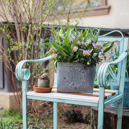 Iron carry flower pot gray with Home Sweet Home embossing on turquoise bench with blooms on Tampa Home & Garden Store