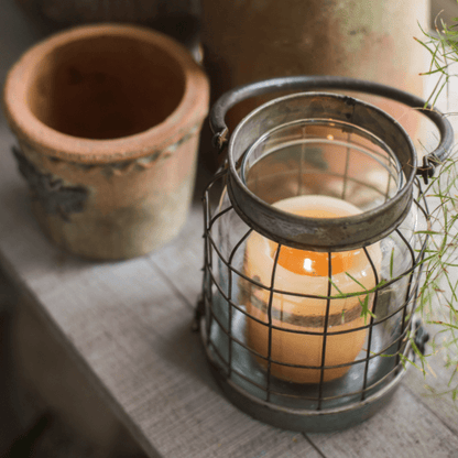 European Restoration Candle Holder in dark metal with glass hurricane lantern on wooden table on Tampa Home & Garden Store