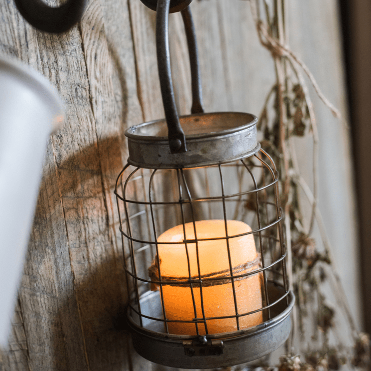 European Restoration Candle Holder RusticReach metal cage lantern with amber pillar candle on Tampa Home & Garden Store