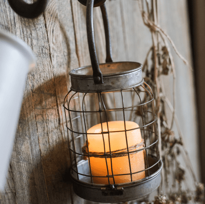 European Restoration Candle Holder RusticReach metal cage lantern with amber pillar candle on Tampa Home & Garden Store