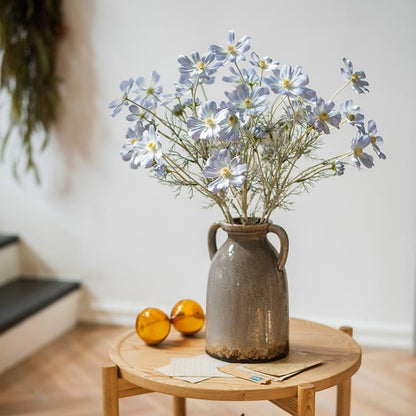 Faux Silk Cosmos Stem Blue 24in Tall RusticReach arranged in a brown ceramic pitcher on a round wooden table on Tampa Home & Garden Store