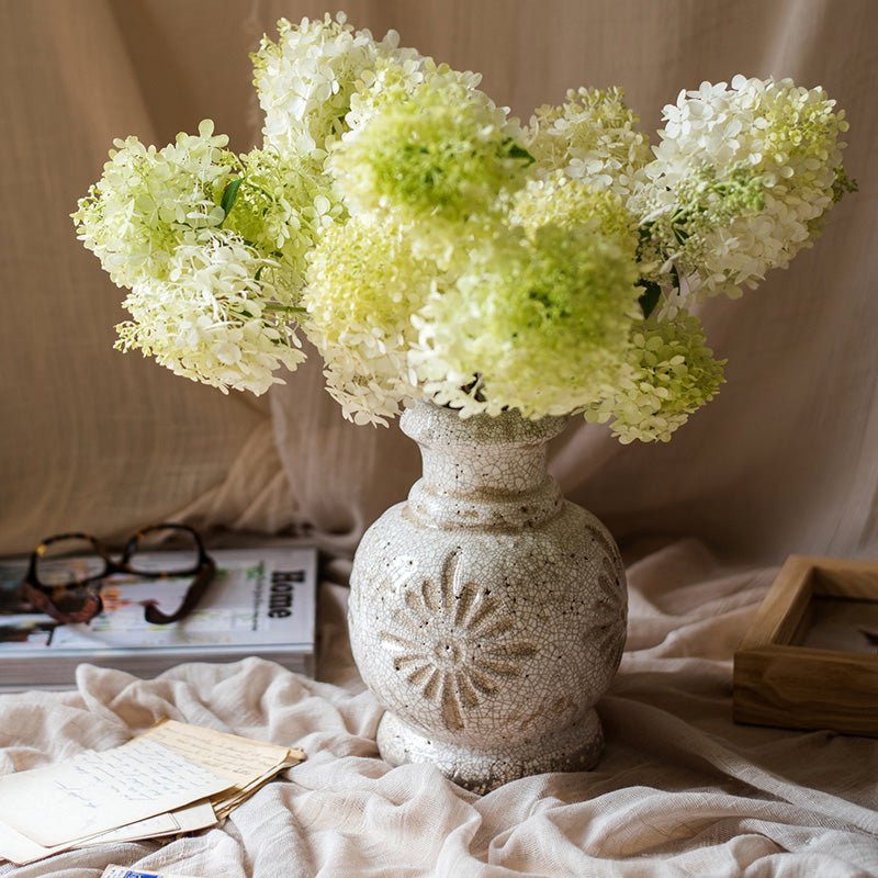 White carved floral ceramic vase with crackle glaze holding pale green hydrangea bouquet on Tampa Home & Garden Store