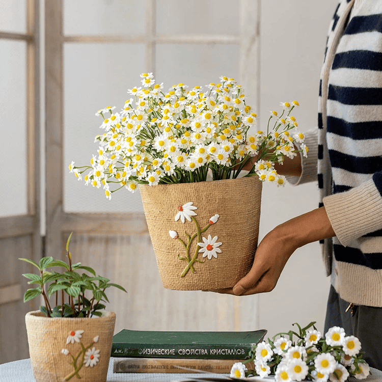 Daisy garden planter in a woven jute pot with embroidered daisies, held by a person on Tampa Home & Garden Store