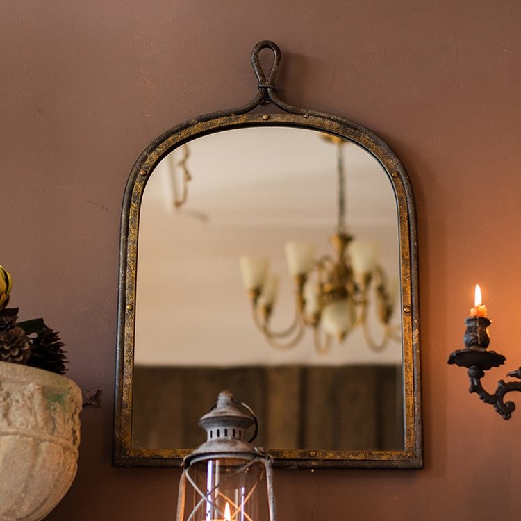 Antique style dark iron mirror with aged patina and top hanging loop, reflects a chandelier on Tampa Home & Garden Store