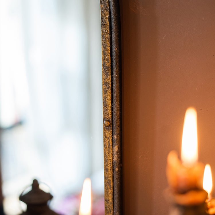 Antique Style Dark Iron Mirror with rustic patina frame; close-up edge and candlelight glow on Tampa Home & Garden Store