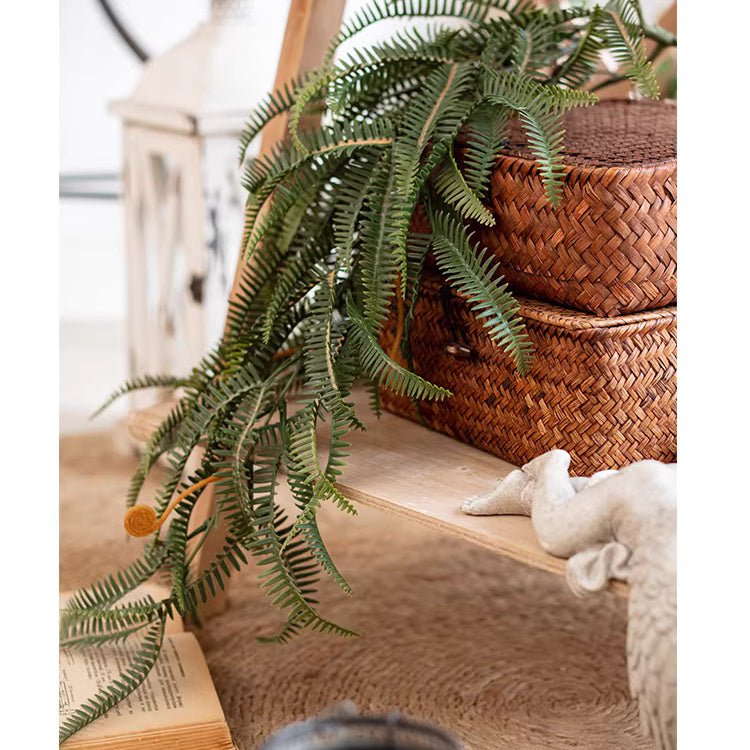 Evergreen fern garland and wreath drapes over a wooden surface beside a woven basket on Tampa Home & Garden Store