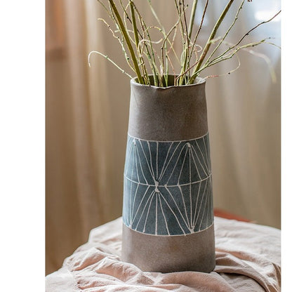 Gray blue handpainted terracotta table vase with blue band and white lines containing dried stems on Tampa Home & Garden Store