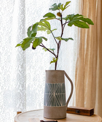 Gray blue terracotta table vase with teal geometric band and branch beside wooden box on Tampa Home & Garden Store