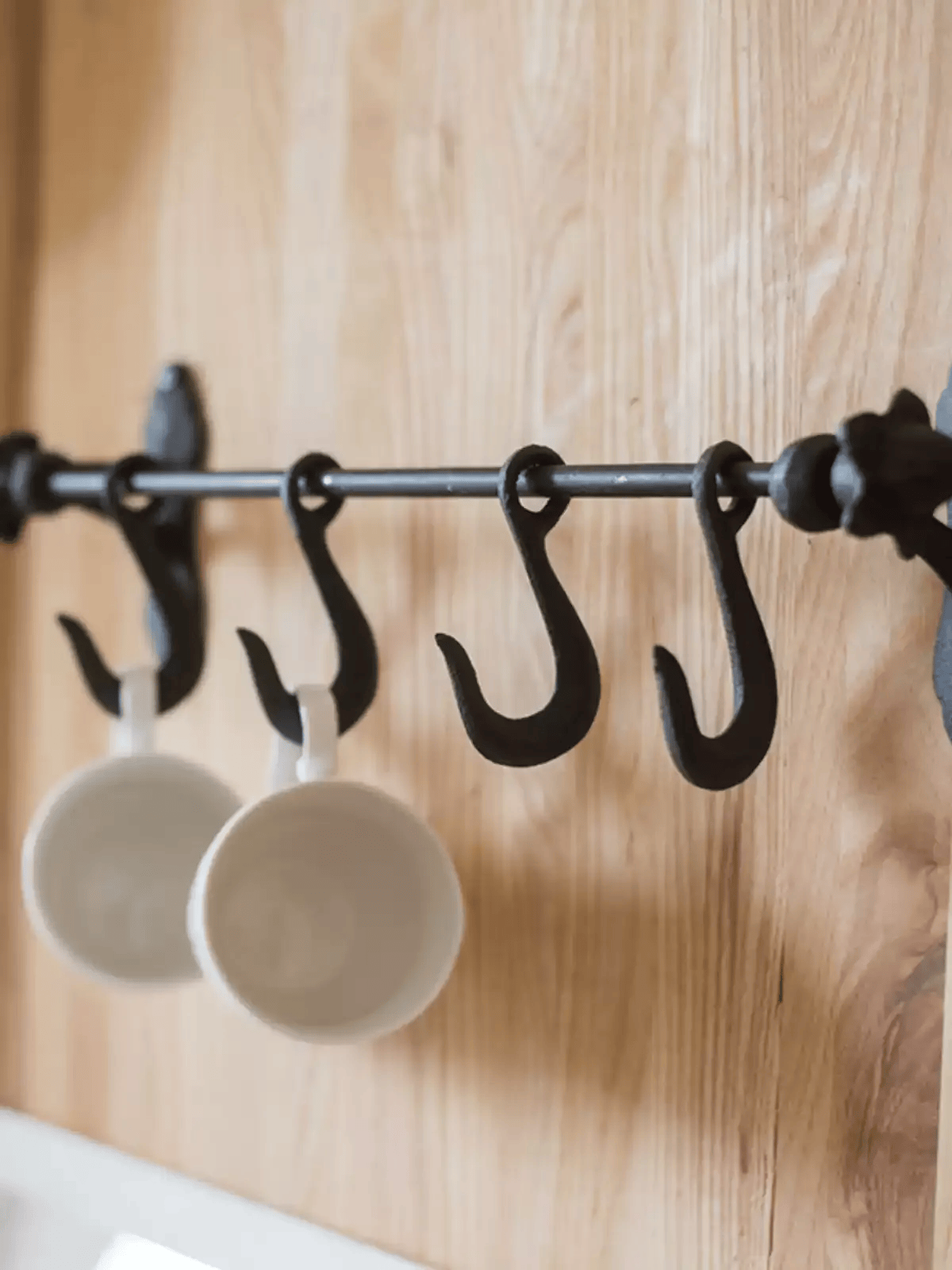Farmhouse Iron Hook Rail by RusticReach with four black iron S-hooks on wood wall on Tampa Home & Garden Store