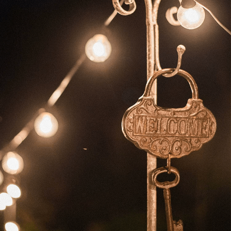 Farmhouse vintage key wall accent in bronze with WELCOME hanging beside warm string lights decor on Tampa Home & Garden Store