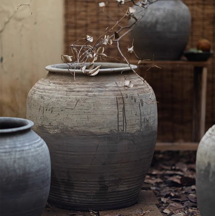 Large antique ceramic pot by RusticReach with weathered gray glaze and dried branch inside on Tampa Home & Garden Store