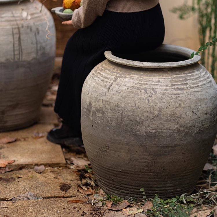 Two large antique ceramic pots with weathered gray finish and textured surface in an outdoor garden setting on Tampa Home & Garden Store