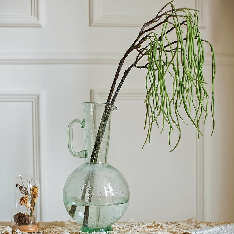 Artificial Let Fall Plant Stem 29in tall in a glass pitcher with long drooping green leaves on Tampa Home & Garden Store