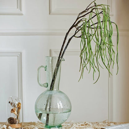 Artificial Let Fall Plant Stem 29in tall in a glass pitcher with long drooping green leaves on Tampa Home & Garden Store