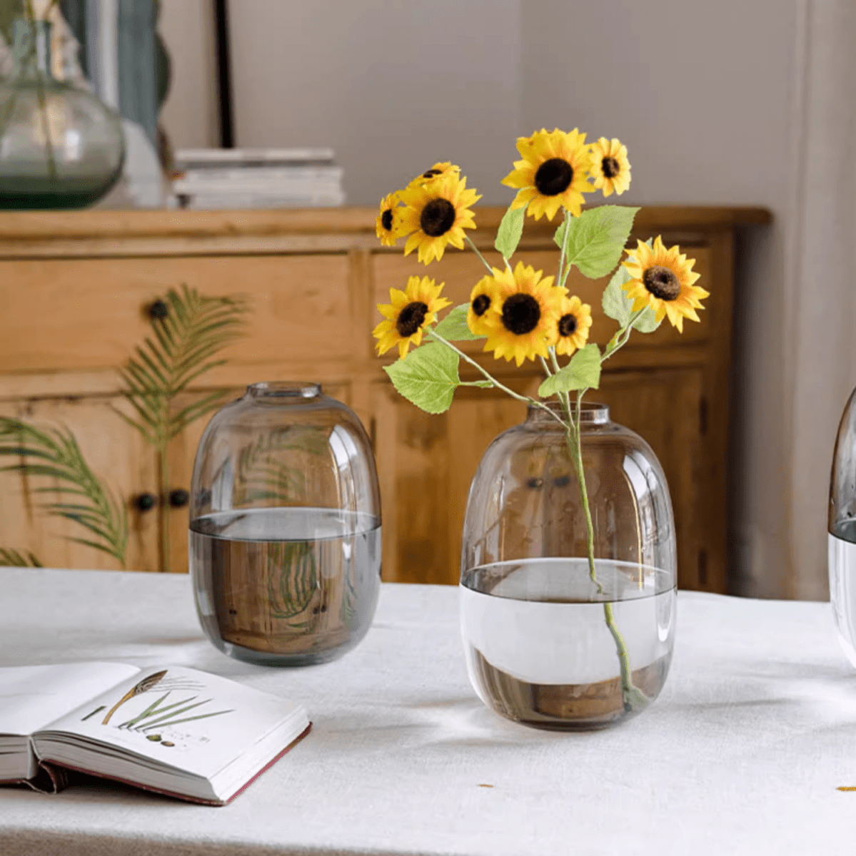 Modern clear glass vase by RusticReach holding sunflower stems with water on a white table on Tampa Home & Garden Store