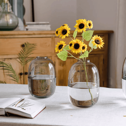Modern clear glass vase by RusticReach holding sunflower stems with water on a white table on Tampa Home & Garden Store