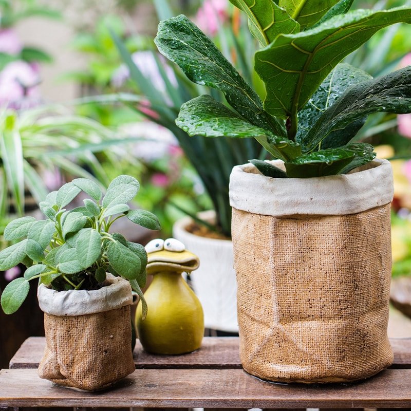 Paper Bag Style Concrete Garden Pot pair with burlap-wrapped planters and greenery on table on Tampa Home & Garden Store