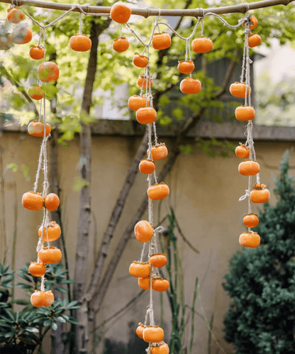 Artificial persimmon fruit string decor with orange fruit on jute twine strands on Tampa Home & Garden Store