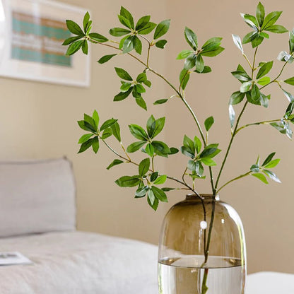 Faux Pieris Branch Stem RusticReach green artificial leaves in a clear glass vase on Tampa Home & Garden Store