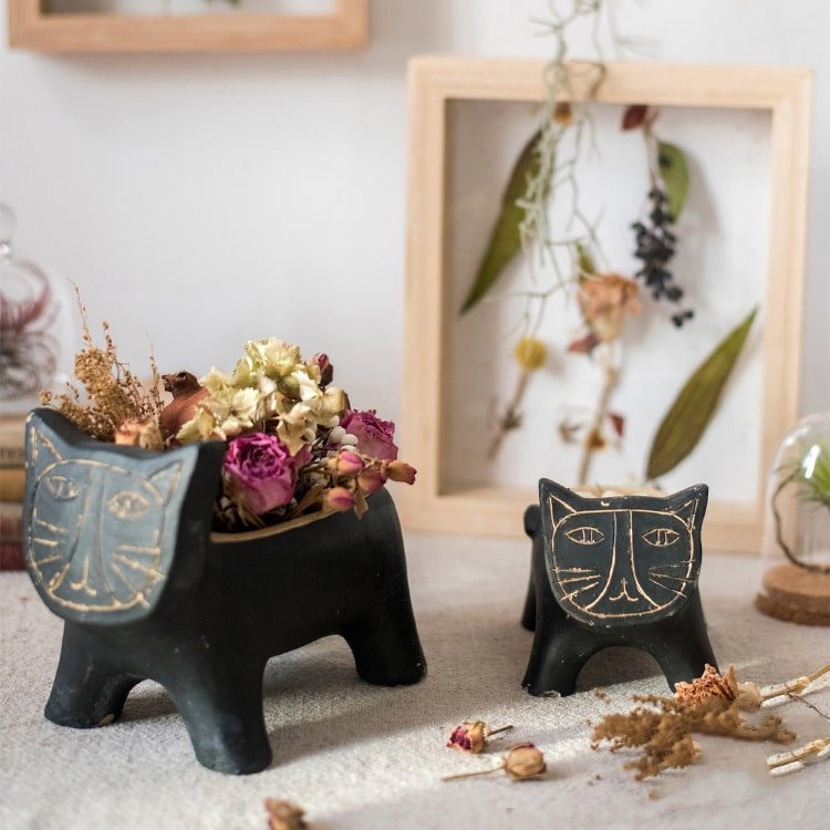 RusticReach cat-shaped concrete planters, black with gold faces, one holds dried flowers on Tampa Home & Garden Store