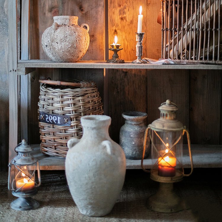Stoneware vase with light gray textured finish on a rustic wooden shelf beside lanterns on Tampa Home & Garden Store