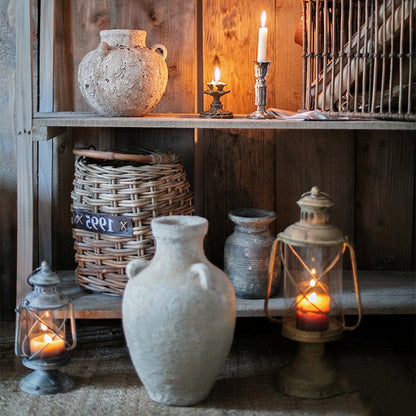Stoneware vase with light gray textured finish on a rustic wooden shelf beside lanterns on Tampa Home & Garden Store