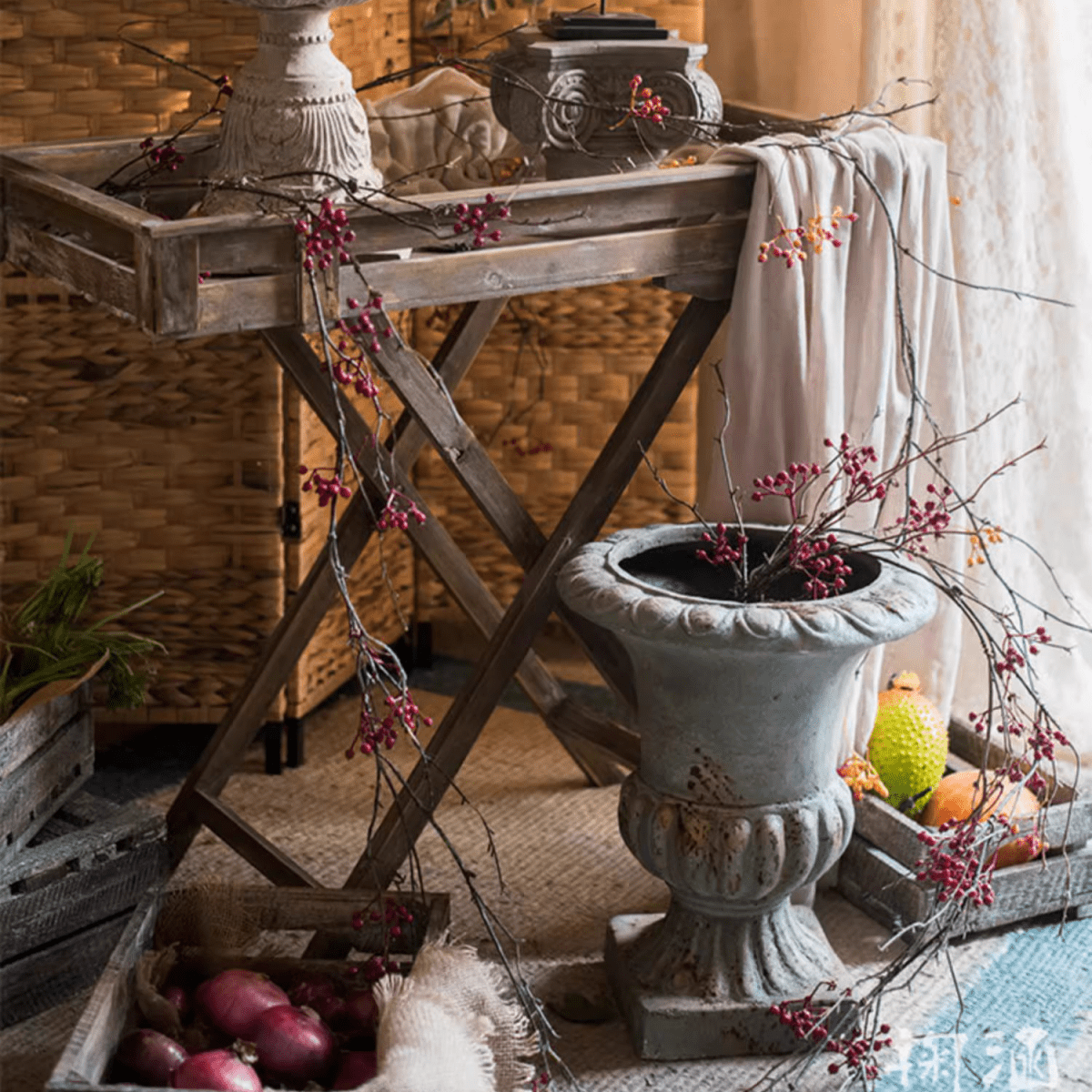 Rustic artificial red berry vine, 63in long, RusticReach decor draped over a weathered urn and table on Tampa Home & Garden Store