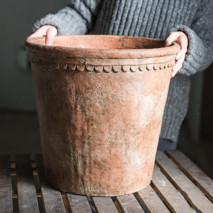 Large terracotta red concrete planter pot with beaded rim detail, weathered surface on Tampa Home & Garden Store