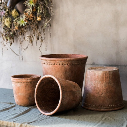 Set of 4 terracotta red concrete planter pots in varying sizes with beaded rims on Tampa Home & Garden Store