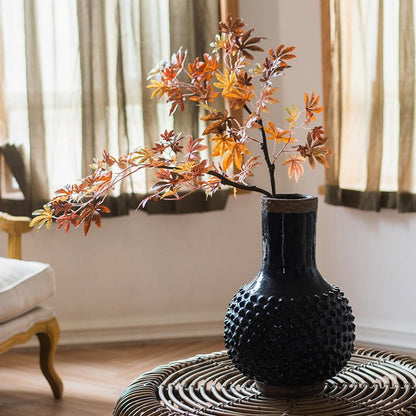 Large navy blue coarse pottery vase with bubbled texture on a wicker table with branches on Tampa Home & Garden Store