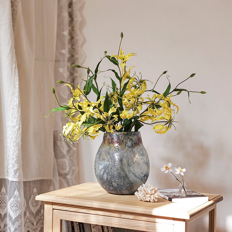 Faux silk flame lily stem in yellow with green leaves arranged in blue glaze ceramic vase on Tampa Home & Garden Store