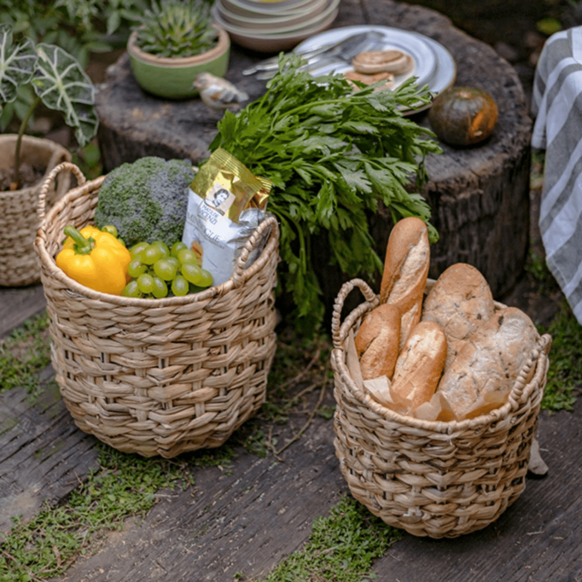 Natural Straw Round Basket with Handles pair by RusticReach, one filled with baguettes and the other with fresh produce on Tampa Home & Garden Store