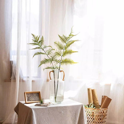 Artificial tall fern leaf stem in clear glass vase with green fronds on white table on Tampa Home & Garden Store