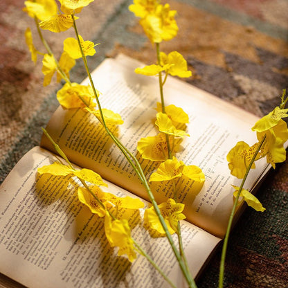 Faux Silk Yellow Dancing Lady Orchid Stem Bundle, 19" tall, orchids arranged on an open book on Tampa Home & Garden Store