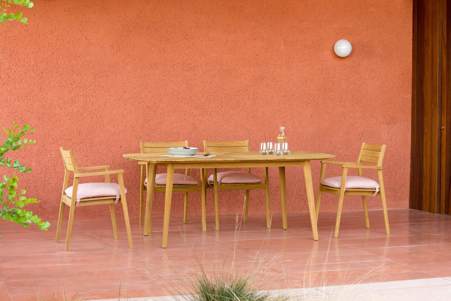4 Jade Teak Stacking Armchairs with terracotta cushions around a teak outdoor dining table on Tampa Home & Garden Store