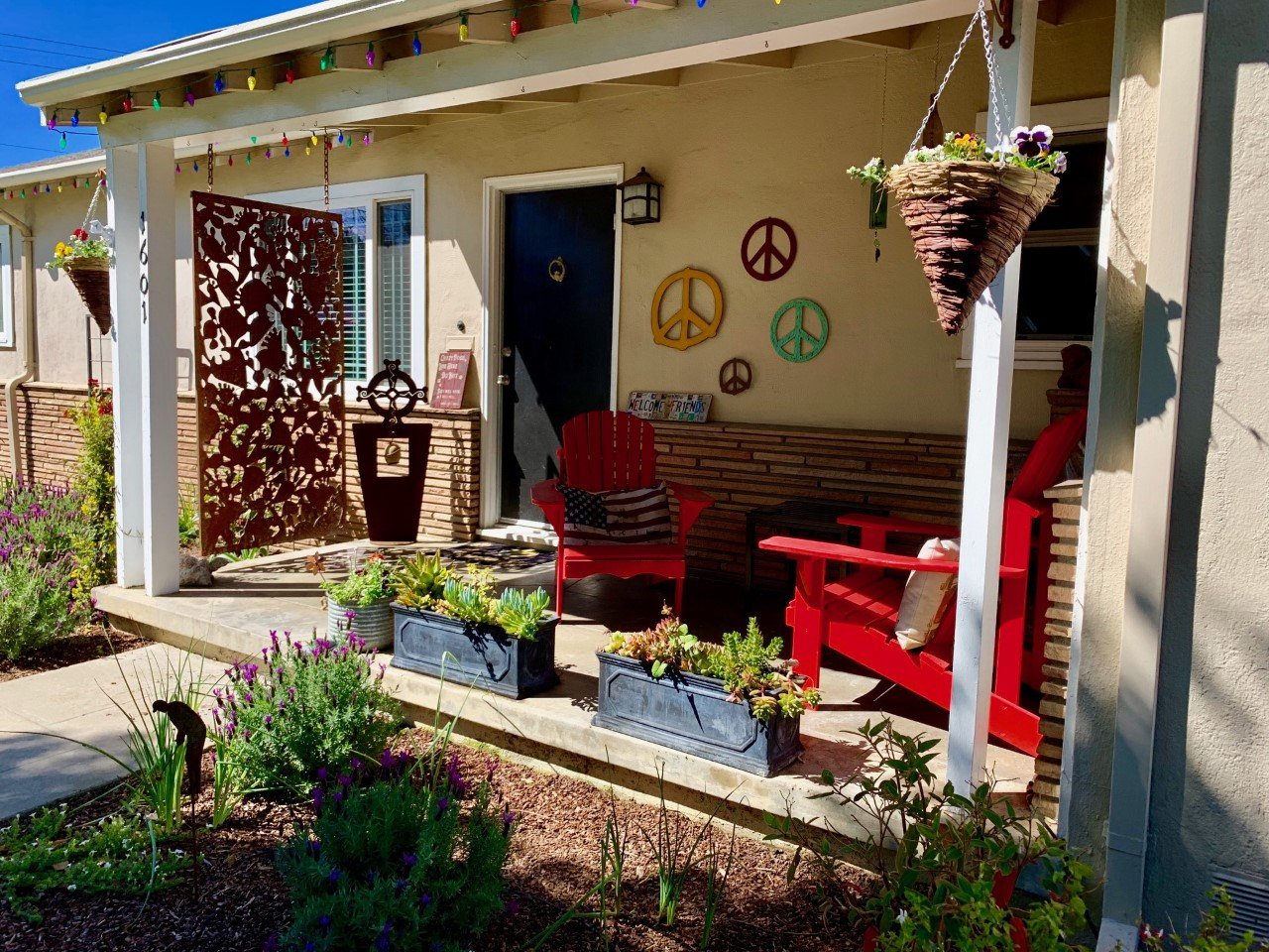 Outdoor metal deck privacy screen panel in dark rust on a sunlit porch with red seating on Tampa Home & Garden Store