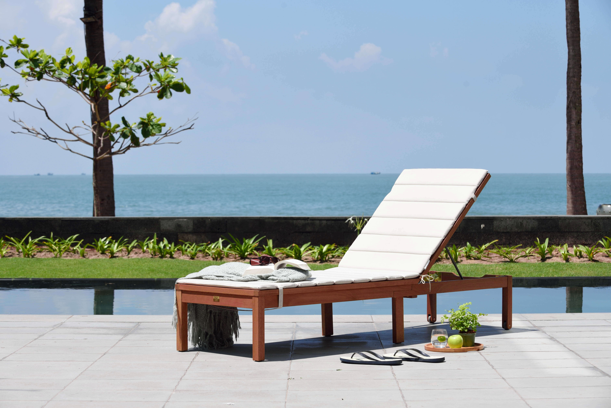 Louisiana dark wood finish wheel lounger with white cushion by poolside deck on Tampa Home & Garden Store