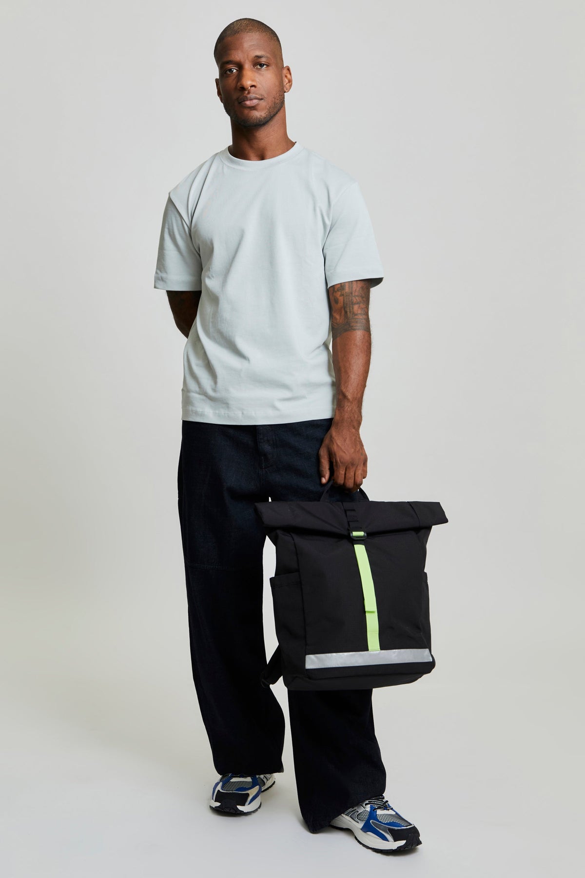 Lefrik Lars Roll Laptop Backpack Black Lime Vandra with lime accent, held by man in light gray tee on Tampa Home & Garden Store
