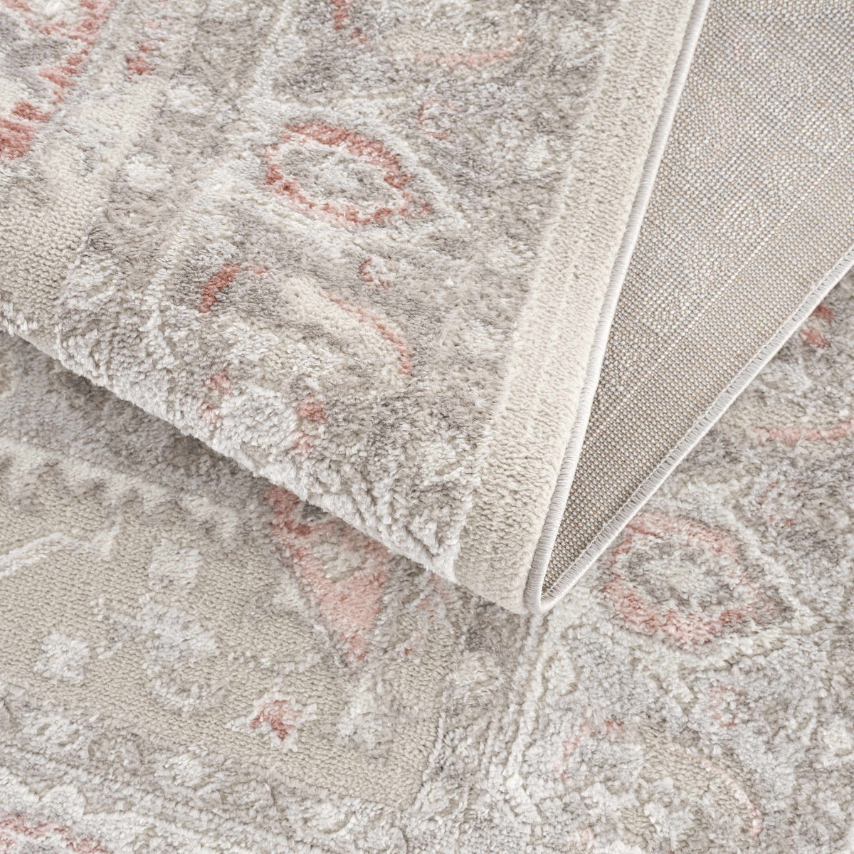 Damla Area Rug plush beige gray pile with pink accents, folded edge shows backing on Tampa Home & Garden Store