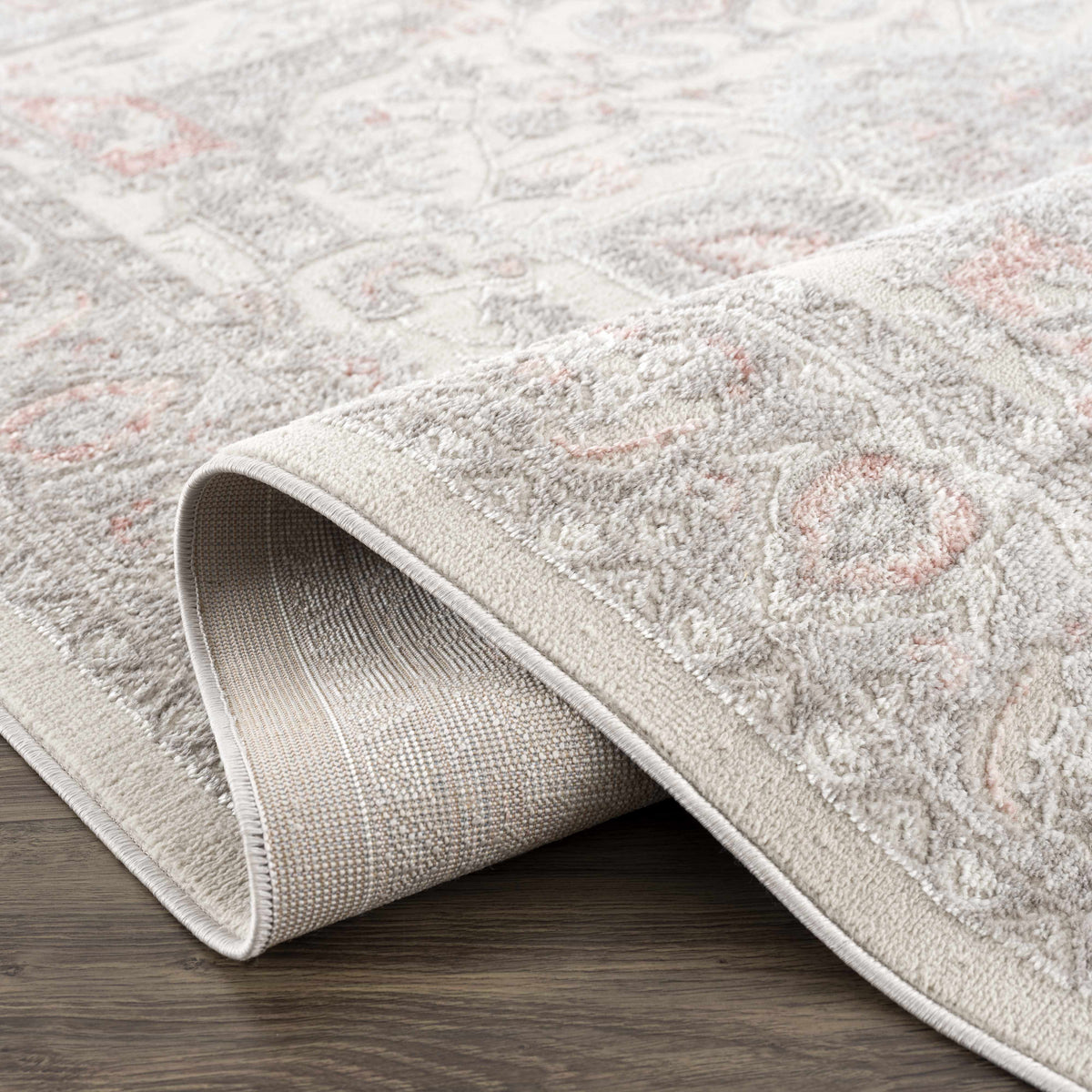 Three Boutique Rugs Damla Area Rug beige-gray with pink accents, plush pile, rolled for display on Tampa Home & Garden Store