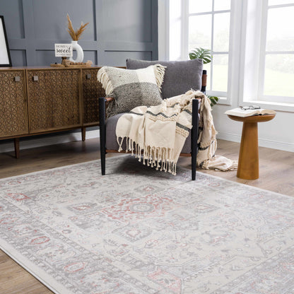Damla Area Rug by Boutique Rugs, light gray with pink accents in a cozy living room on Tampa Home & Garden Store