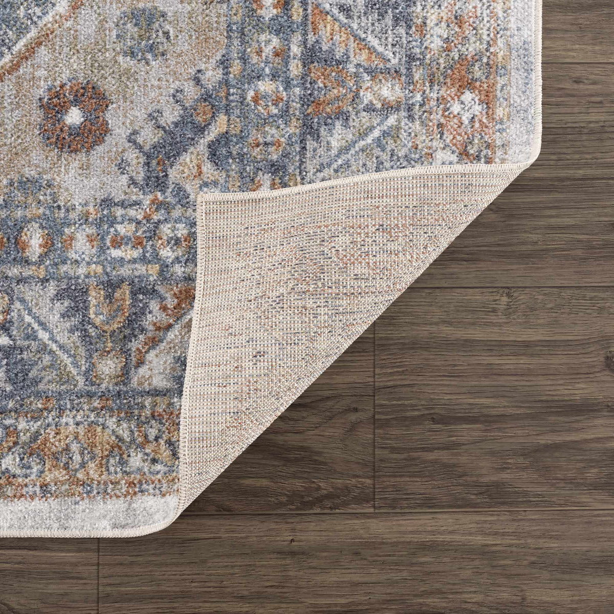 Afya Boutique Washable Rug with blue gray rust abstract pattern on wood floor on Tampa Home & Garden Store