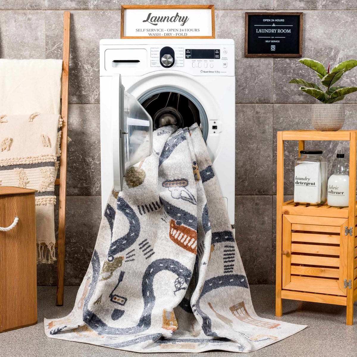 Mave Roads washable rug for kids, gray road-patterned design draped over a laundry washer in a laundry room on Tampa Store