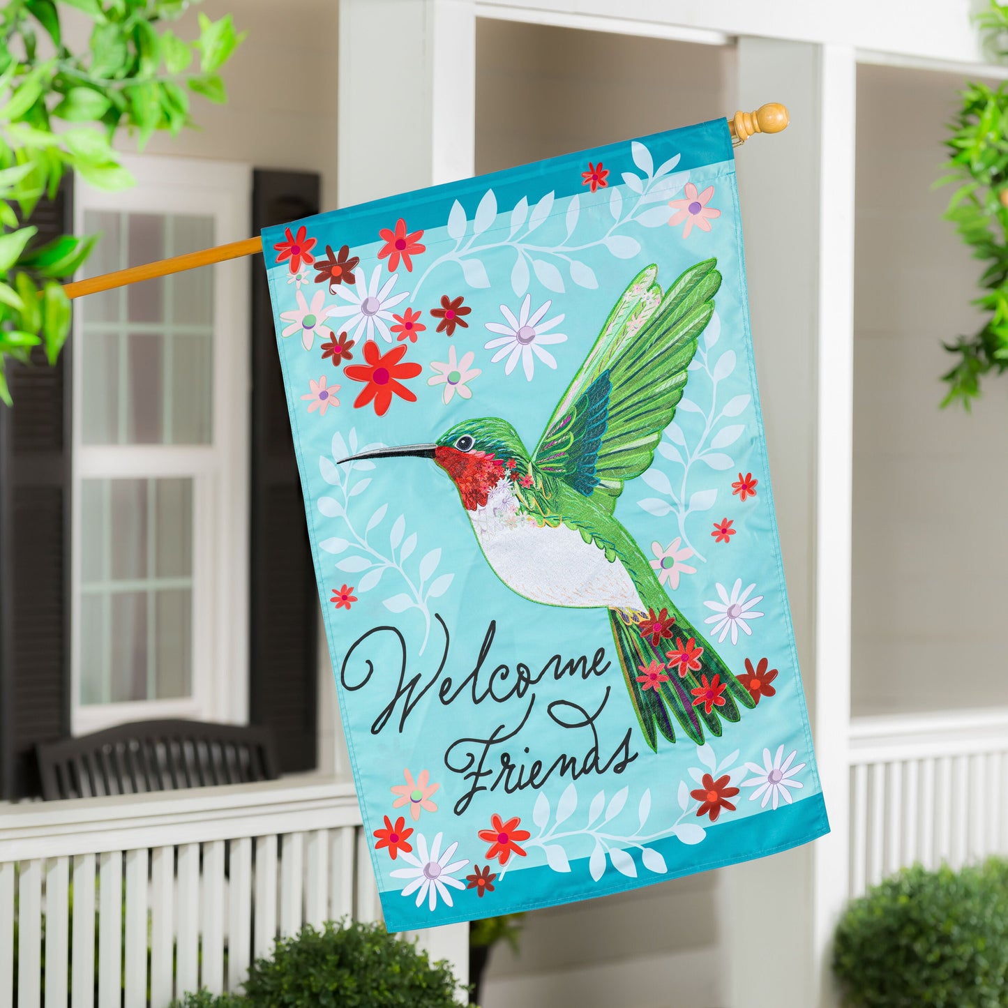 Hummingbird Welcome Applique House Flag turquoise background with flowers and bird on porch on Tampa Home & Garden Store